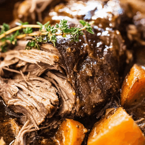 Close-up of juicy meat resting in rich brown gravy.