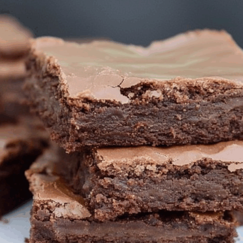 Rich chocolate squares with a glossy ganache topping and a dense, fudgy center