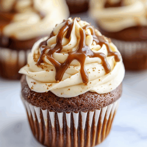 A tray of spiced cupcakes with golden brown tops and decorative toppings.