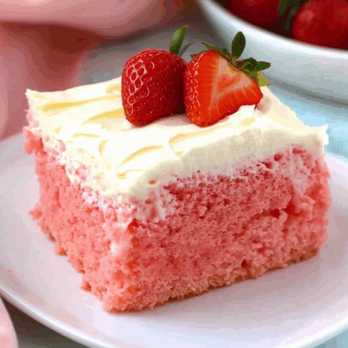 A slice of moist pink cake topped with whipped frosting and fresh berry pieces.
