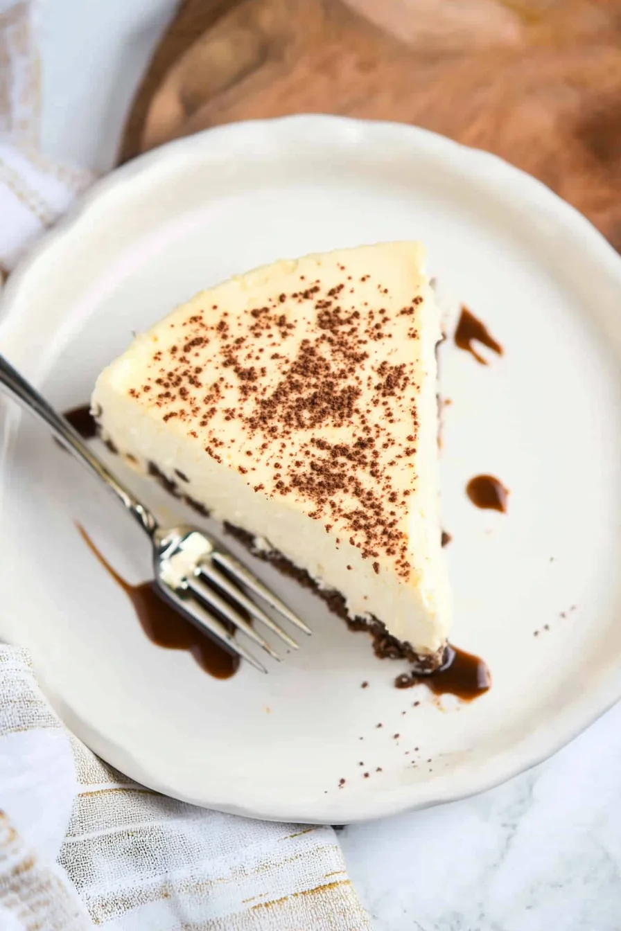 Overhead shot of a plain cheesecake with a golden crust.