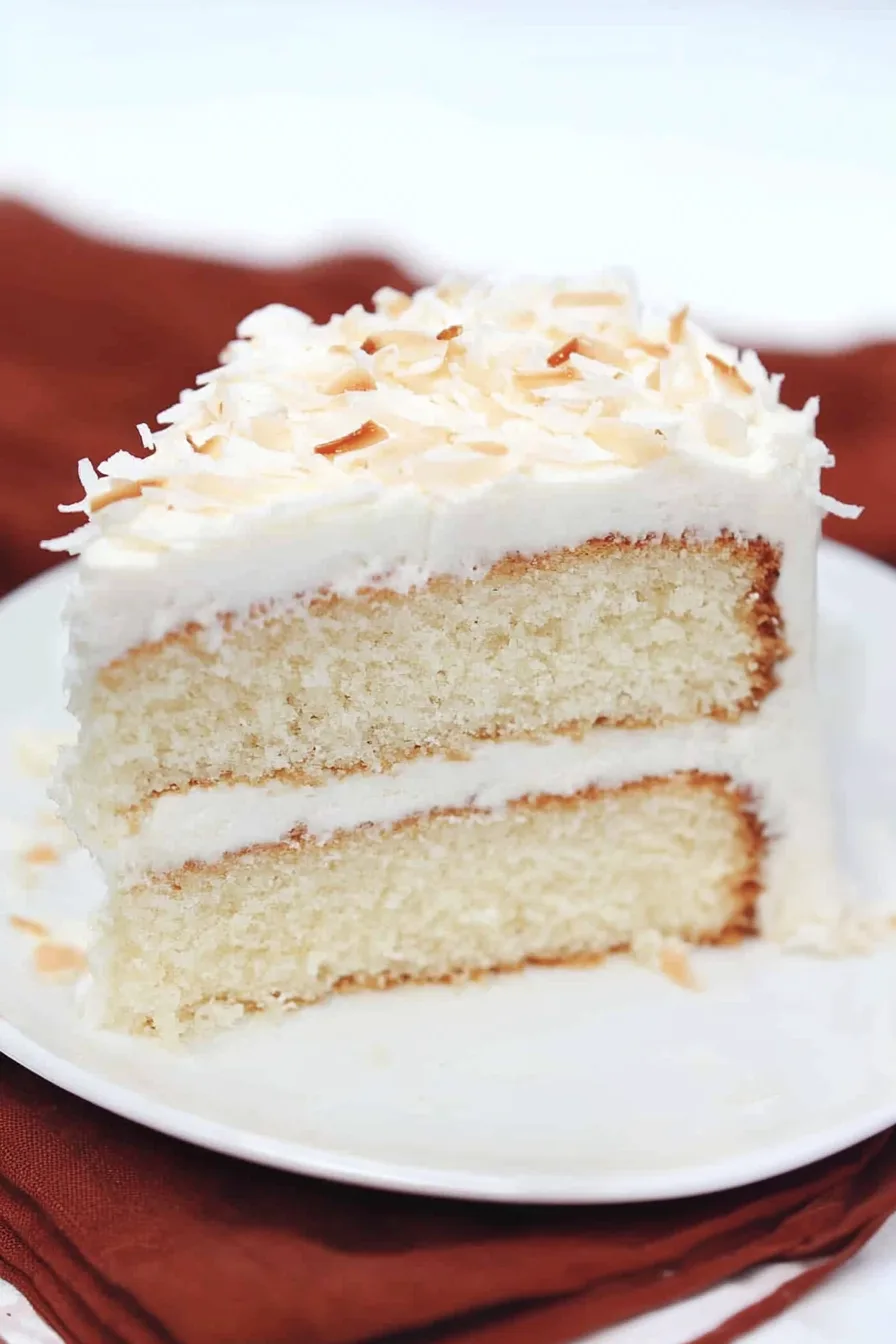 White frosted cake decorated simply with coconut flakes