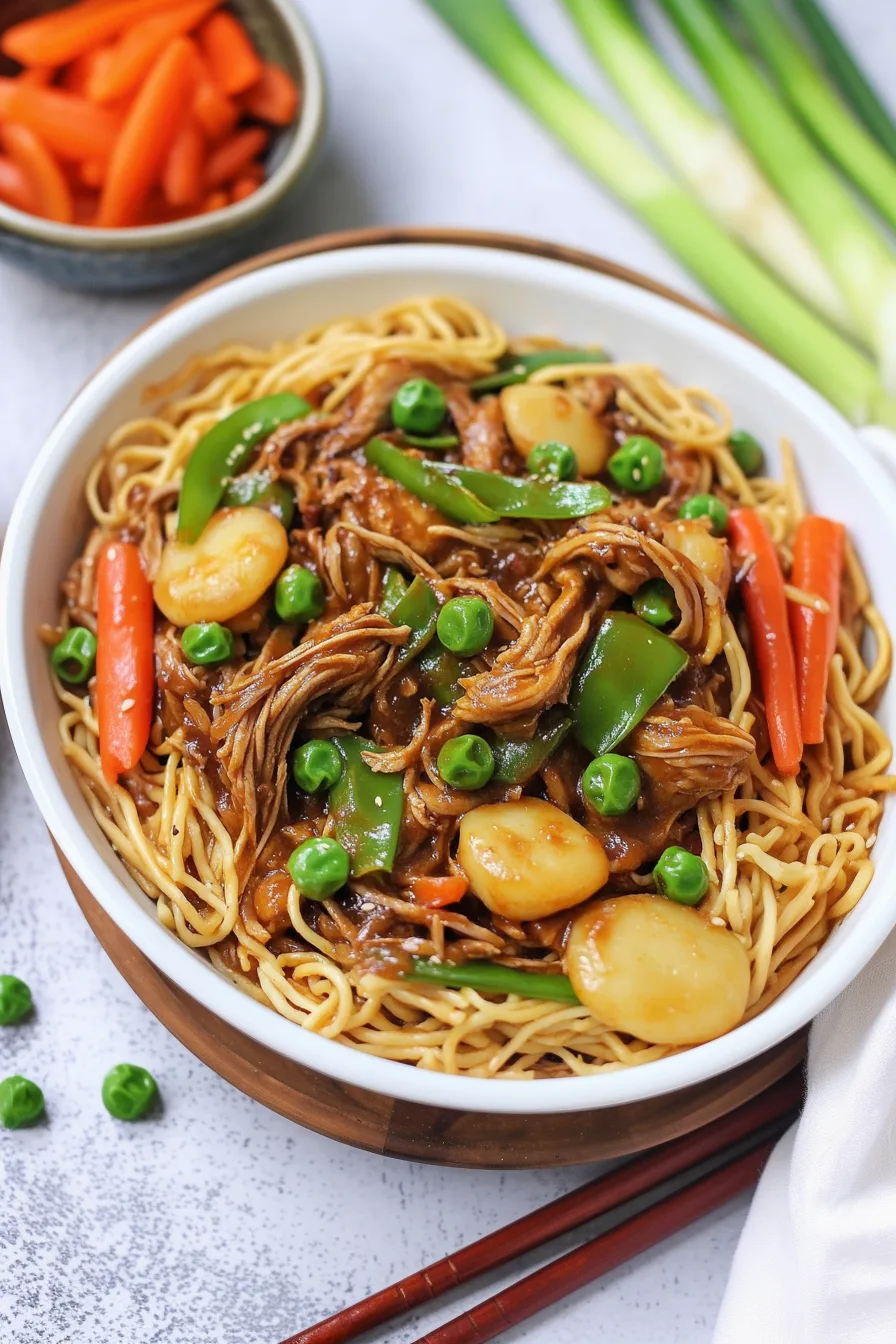 Bowl of stir-fried style noodles served with fresh vegetables.