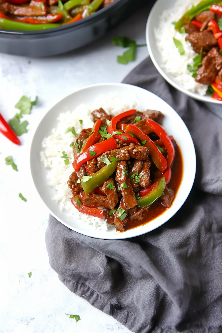 Bowl of beef and bell peppers in a rich, glossy sauce