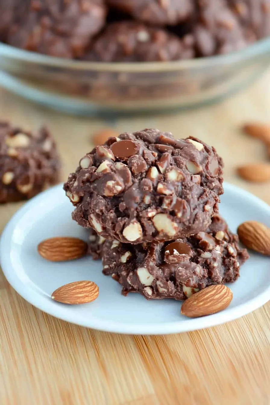 Rustic chocolate cookie clusters with visible bits of nuts and dried fruit on a plate