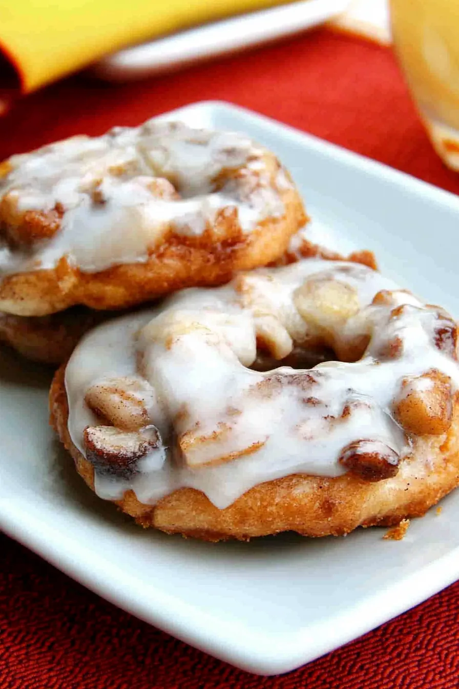 Baked pastry ring on a white serving platter with glossy icing drizzled on top.