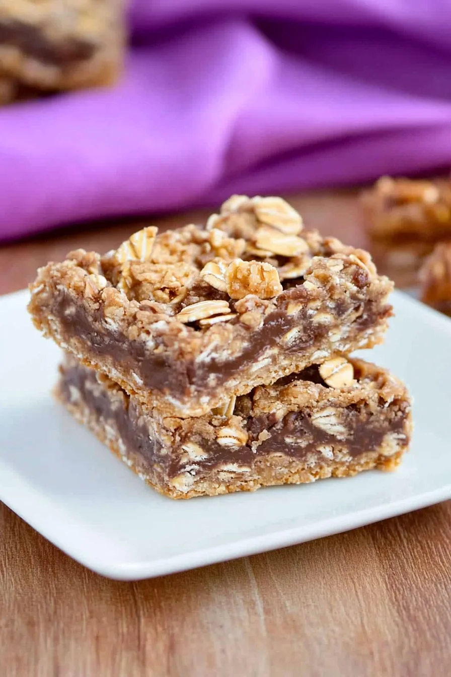 Close-up of layered baked squares with a gooey caramel drizzle