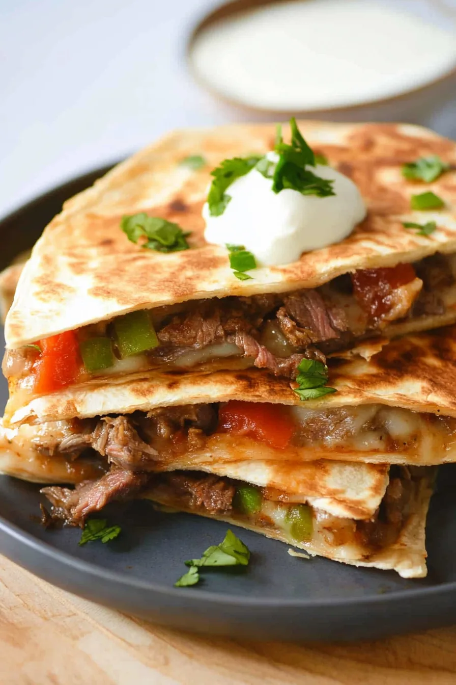 Crispy tortilla wedges stacked on a serving plate with beef and peppers inside