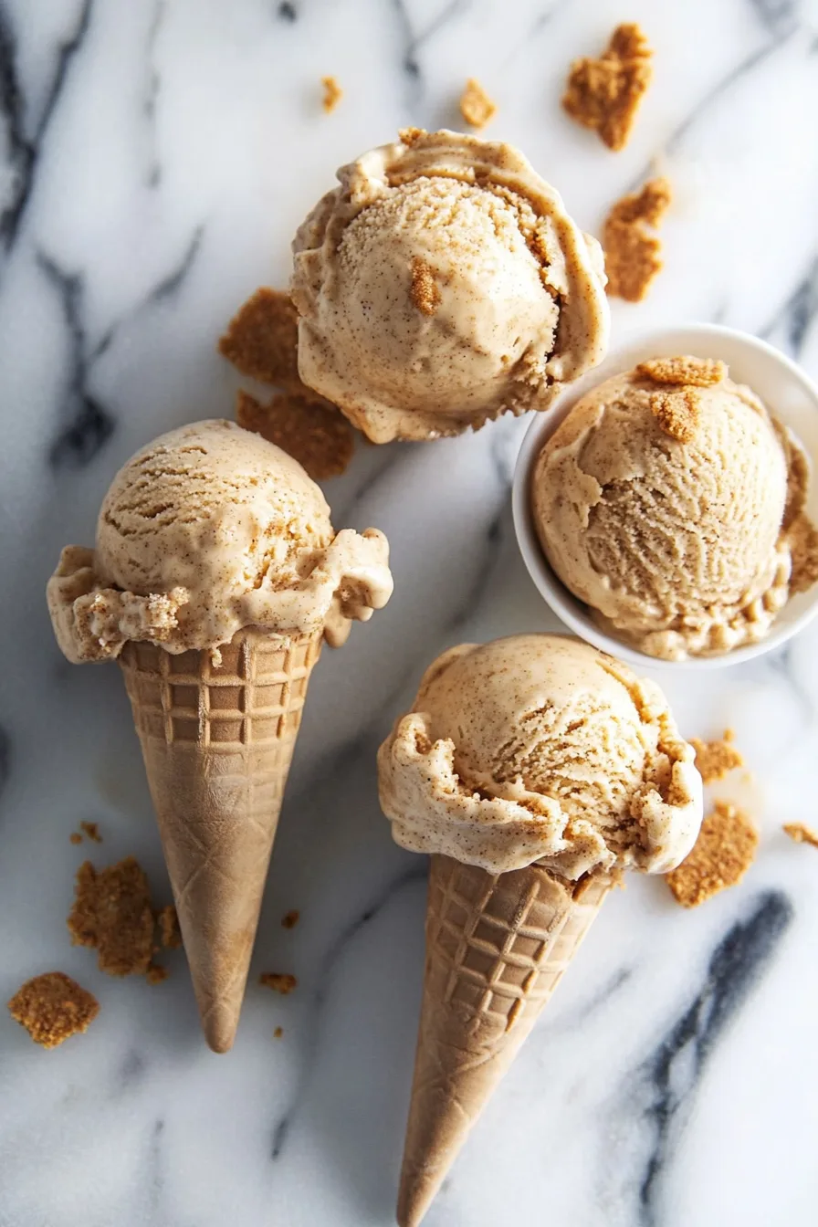Scoops of creamy orange-hued ice cream served in a rustic bow