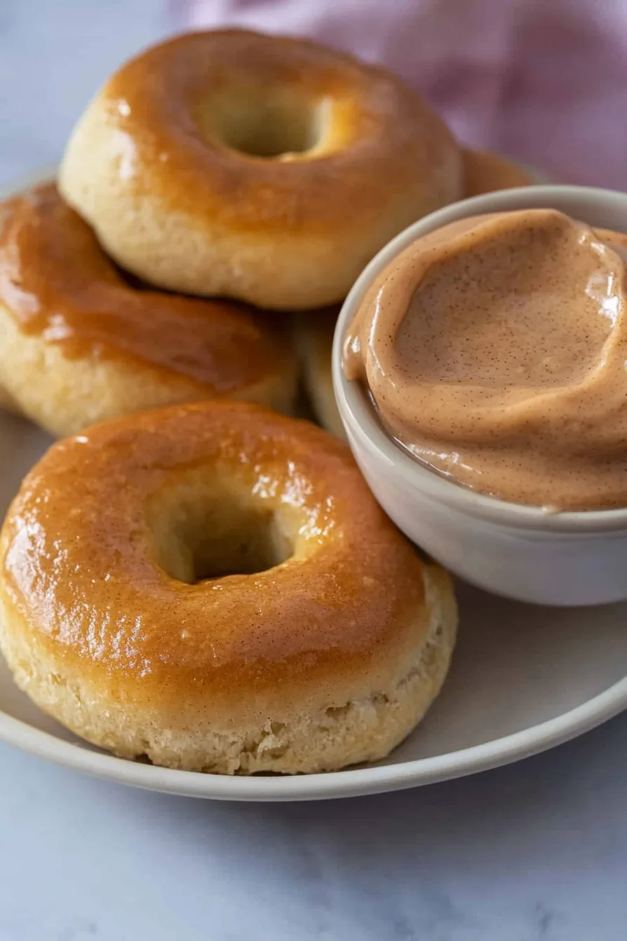 Plate of pillowy rolls stacked beside a small bowl of creamy butter