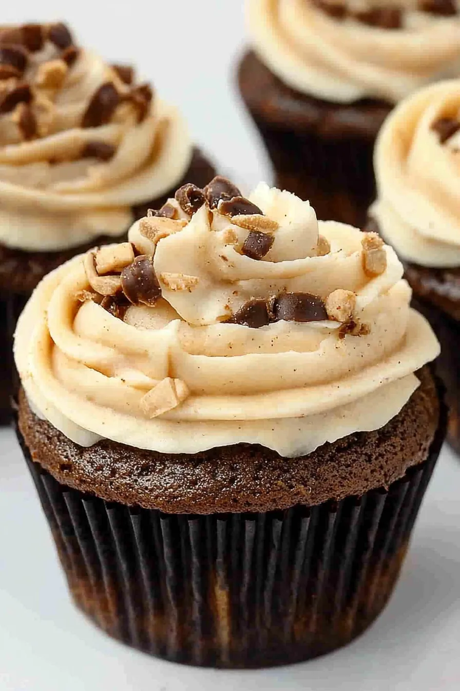 Close-up of chocolate-frosted cupcakes topped with crunchy candy pieces