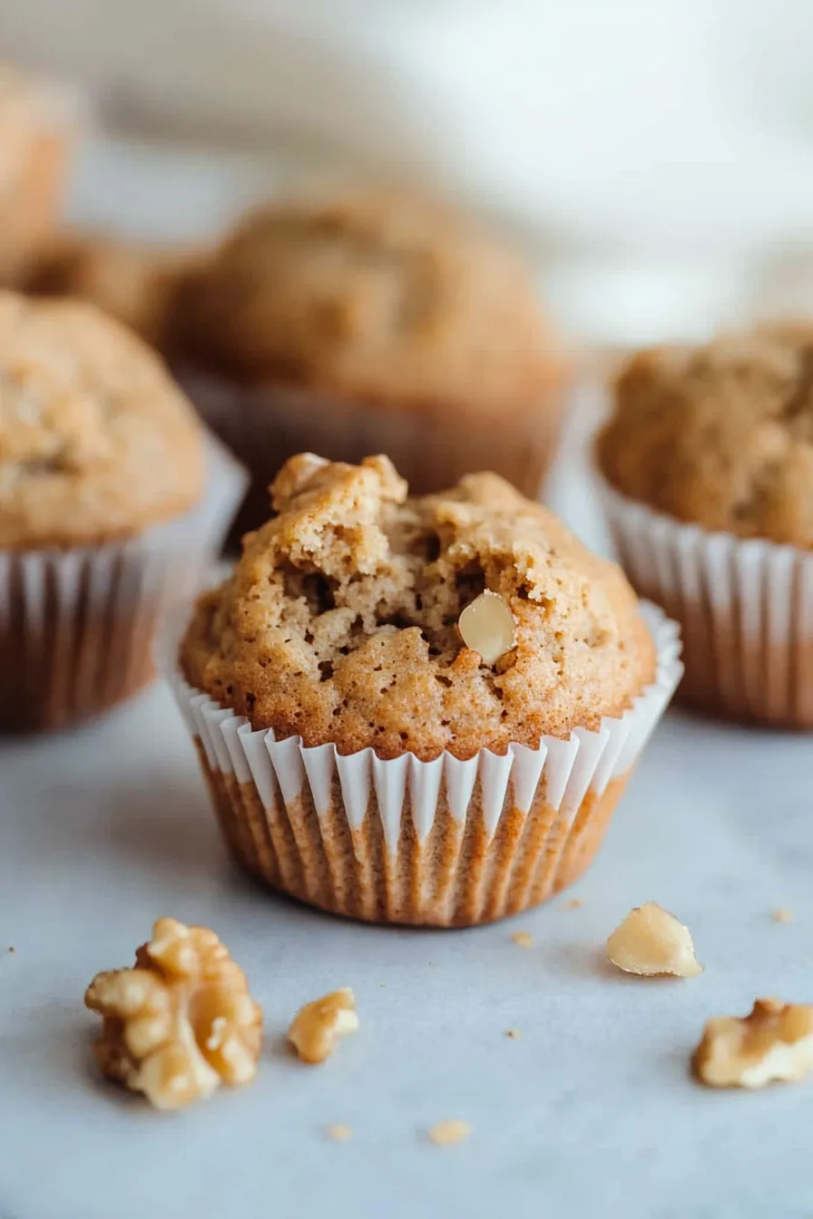 Overhead shot of muffins on a plate with scattered walnuts.