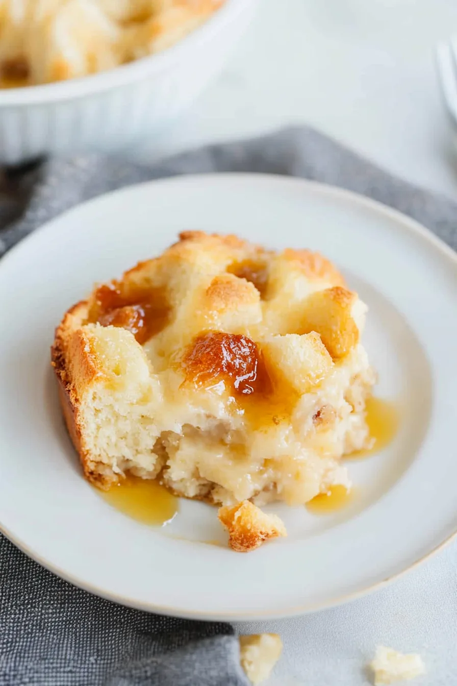 Close-up of a golden bread pudding drizzled with bourbon sauce.