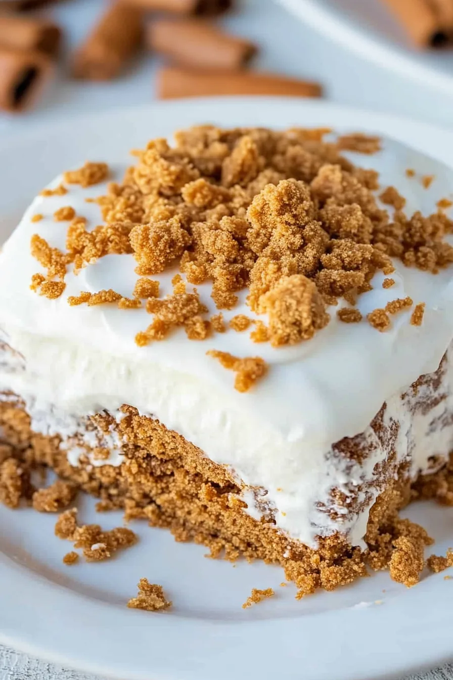 Close-up of moist cake layers with whipped topping and sweet crumble.