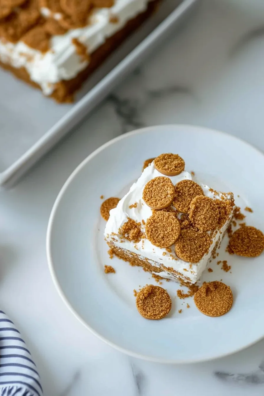 A slice of spiced cake topped with creamy frosting and crumbled brown sugar.