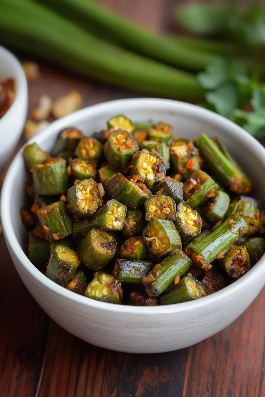 Sautéed okra with onions and spices served in a white bowl.