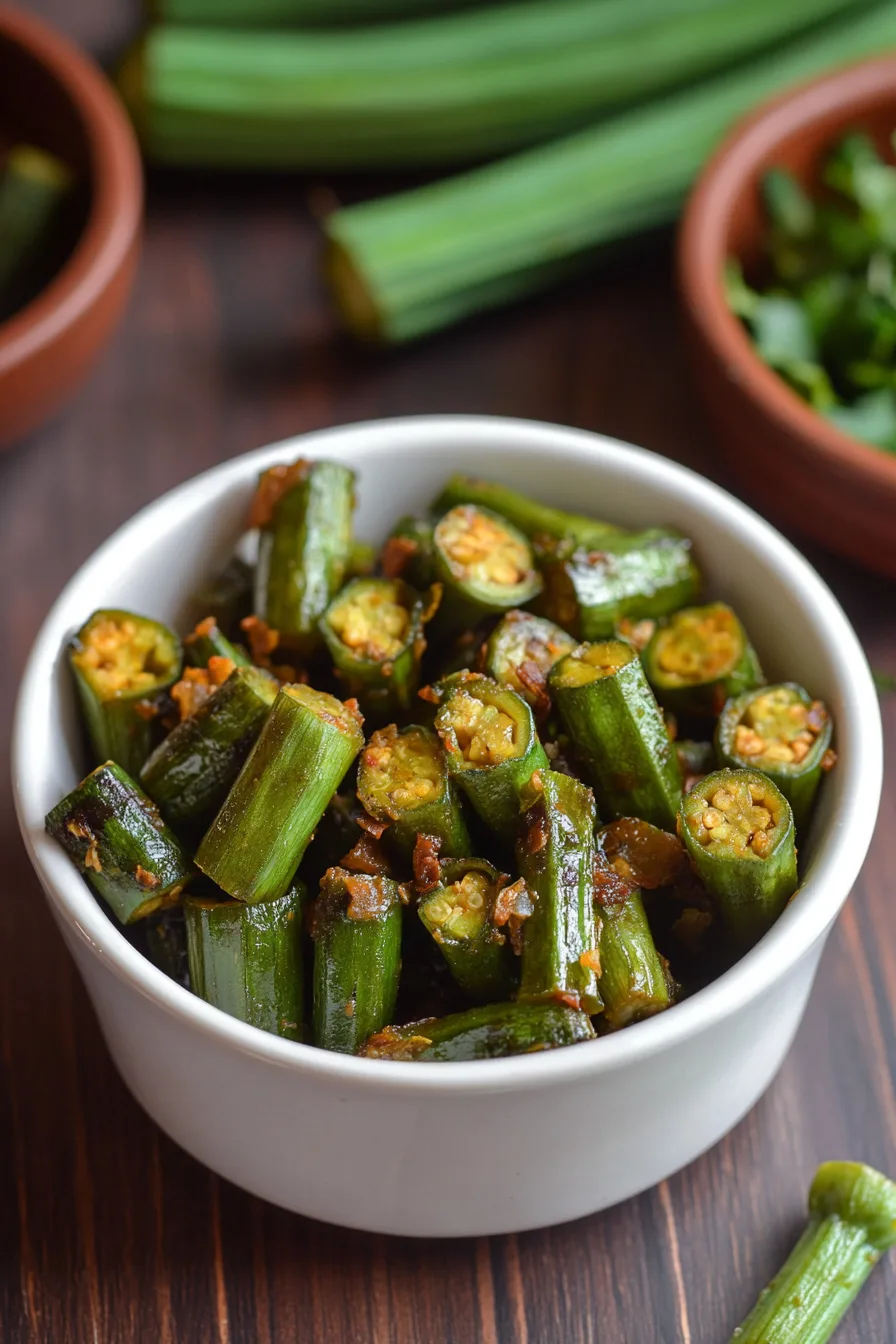 Warm dish of cooked okra with golden-brown onions on top.