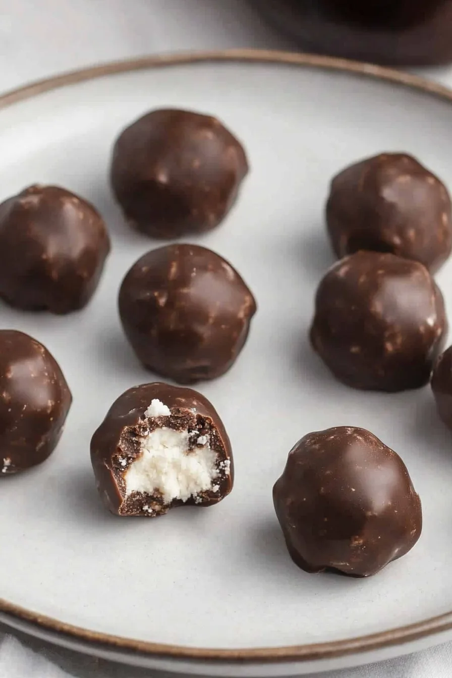 Plate of homemade chocolate treats, one cut open to reveal the creamy center.