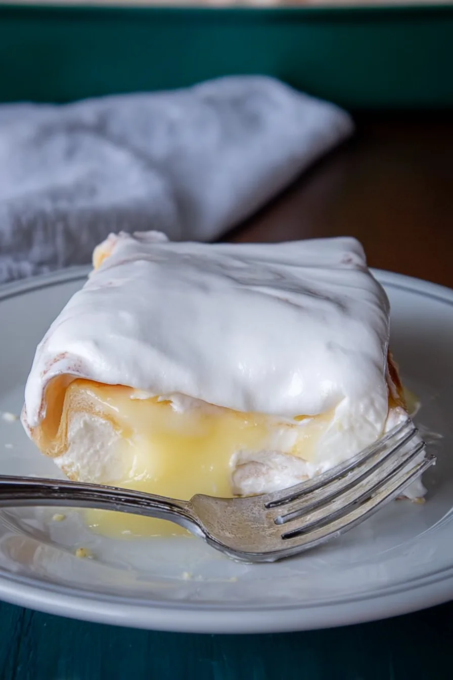 A chilled slice of creamy lemon cake served on a plate.