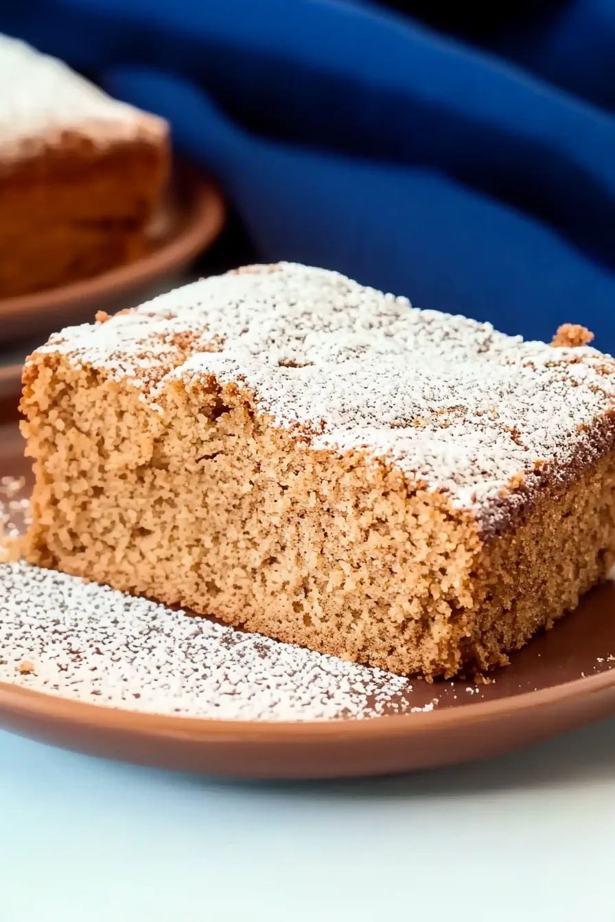 Close-up of a fluffy spice cake piece with a light sugar coating.