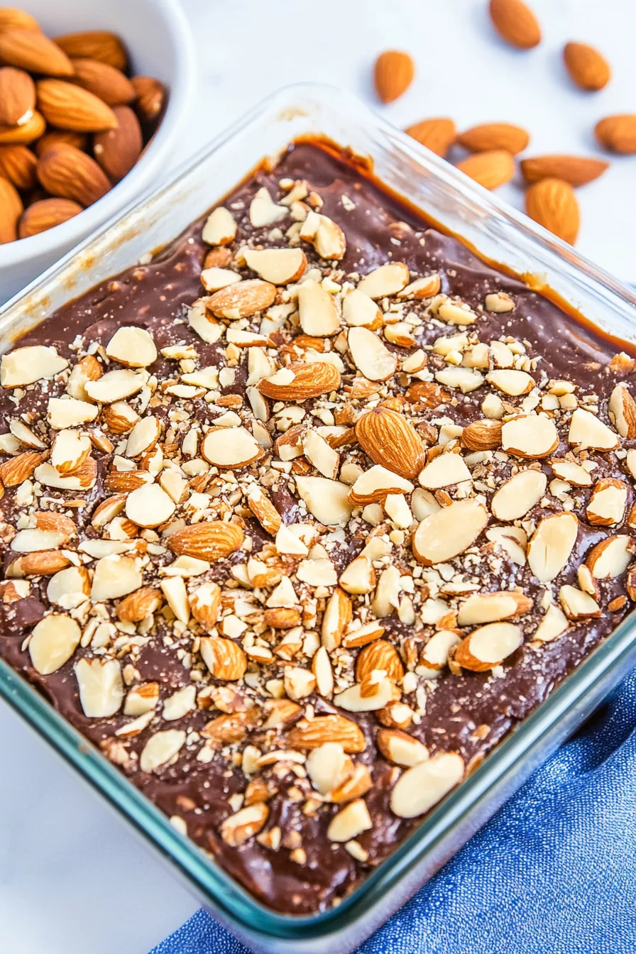 Close-up of homemade almond toffee bark with glossy chocolate and nut pieces.