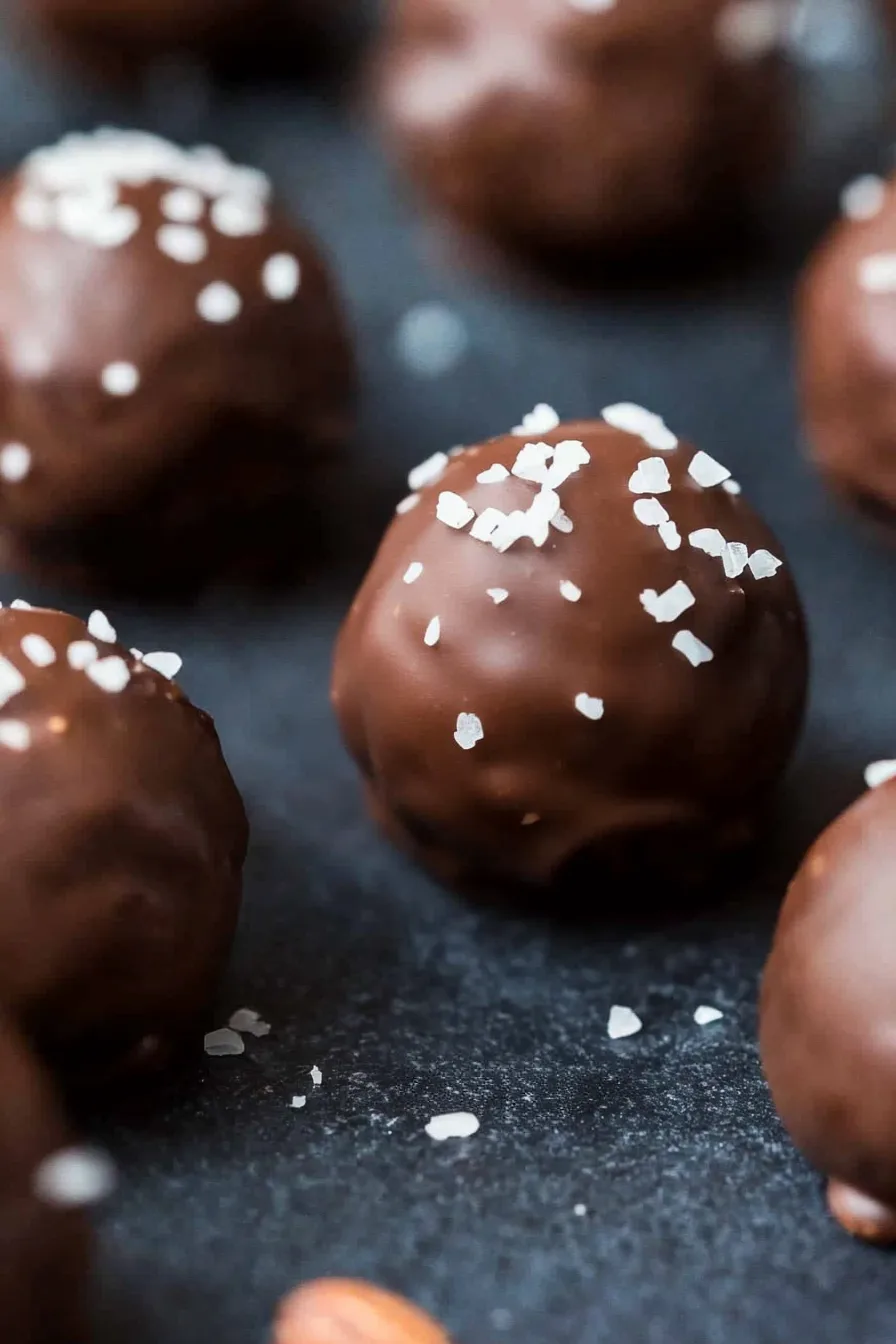 Dark chocolate bourbon candies arranged on a slate board.