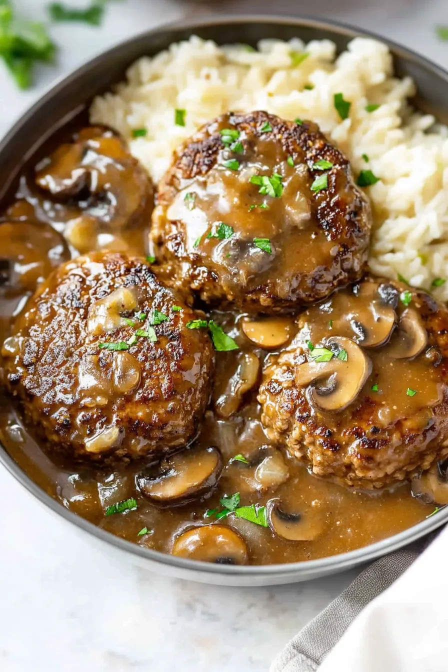 Comfort food dish featuring homemade beef patties and savory gravy sauce.