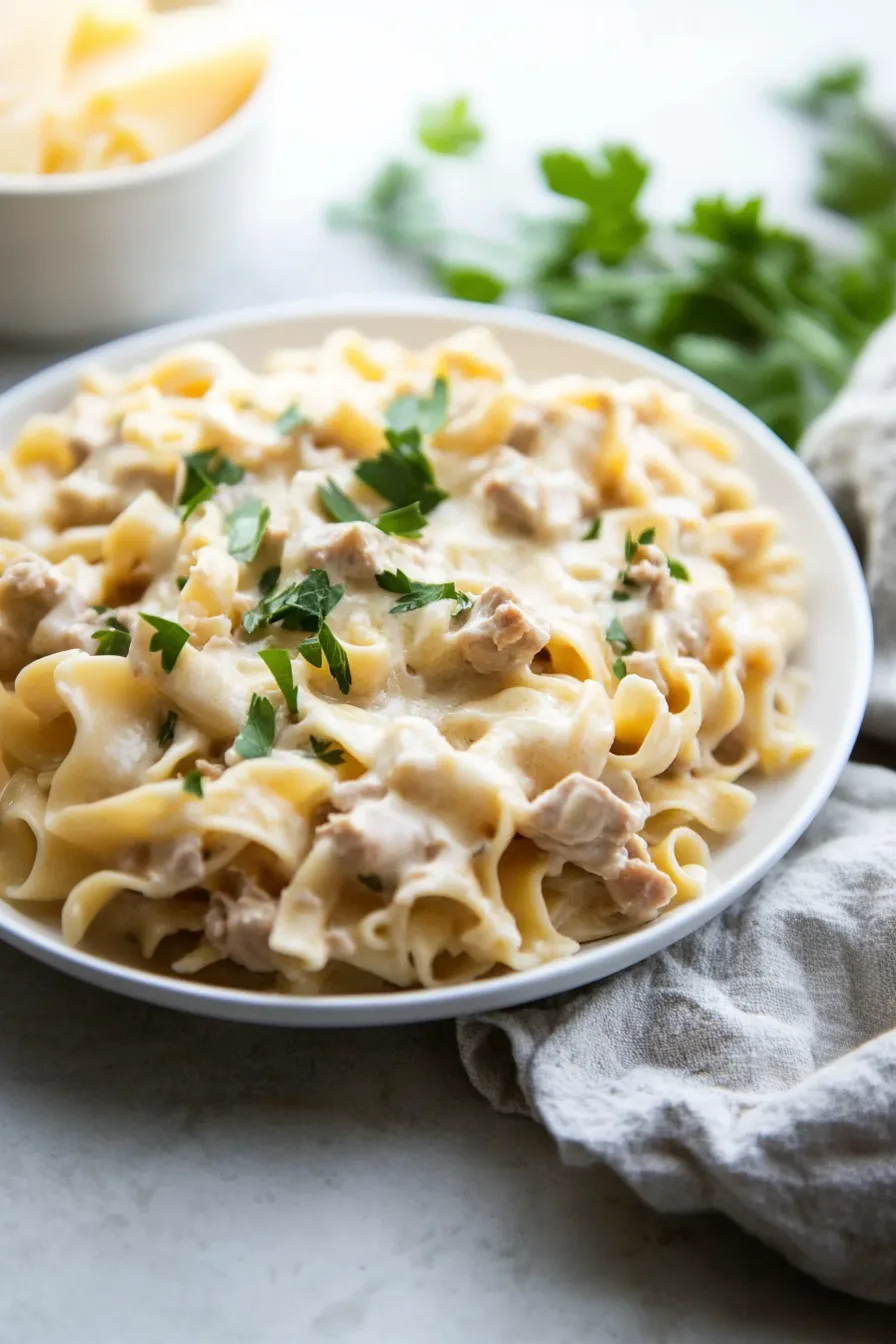Warm and creamy pasta dish garnished with green onions and toasted bits on top.