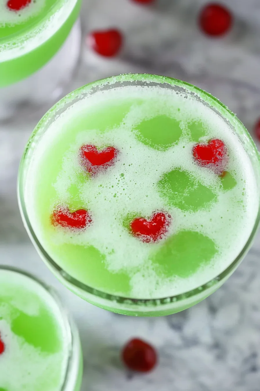 Christmas-themed drink with a red sprinkle sugar rim and floating candy hearts.