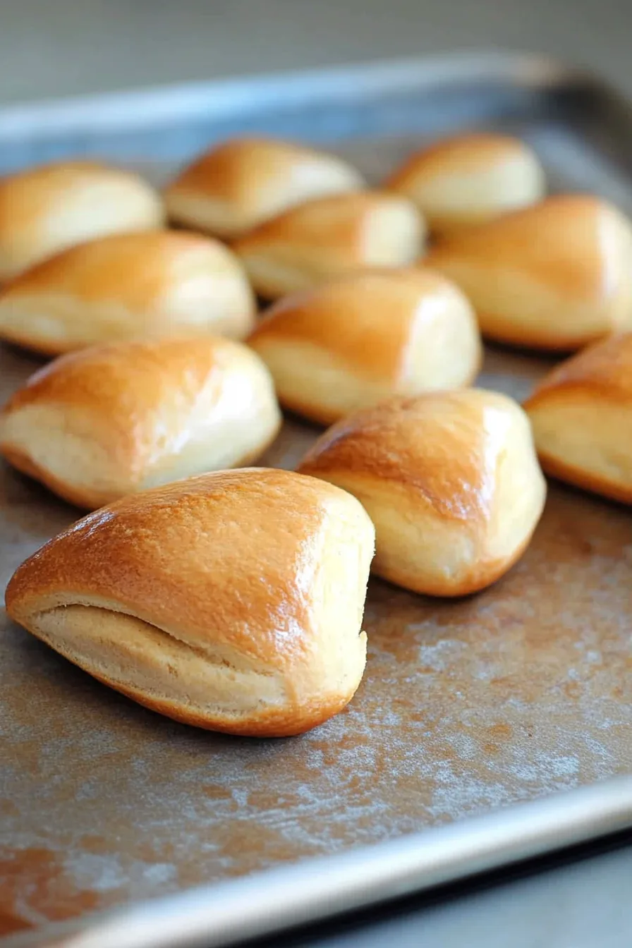 Close-up of homemade rolls cooling on parchment paper.