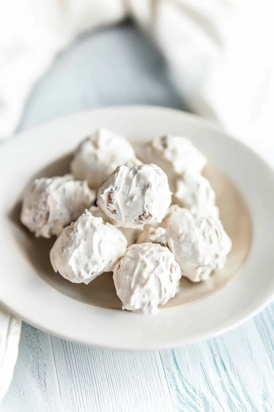 A plate of sweet, nutty meringue treats with a crisp exterior.