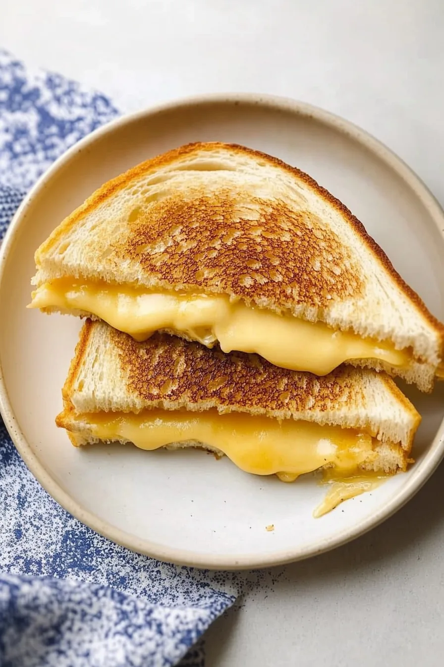 Buttery toasted bread stacked to reveal melty cheese layers.