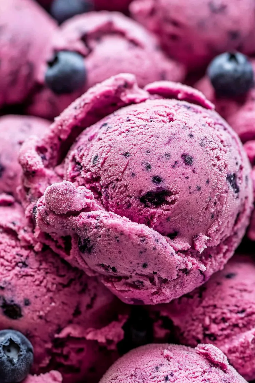 Close-up of homemade berry frozen yogurt topped with whole blueberries.