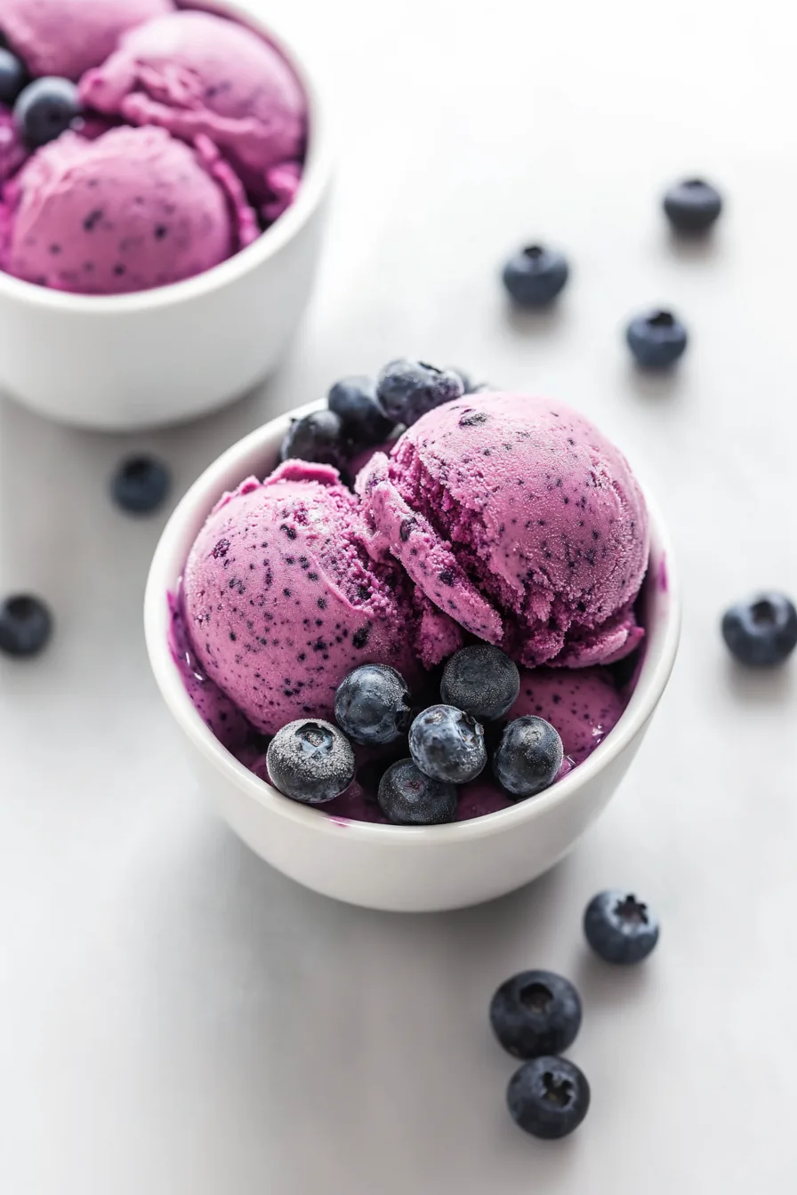 Smooth and colorful berry-blended frozen yogurt displayed in a small white bowl.