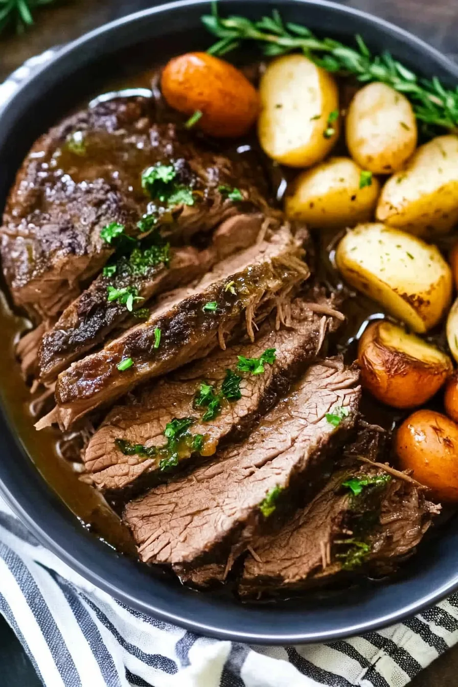 Close-up of a hearty main dish featuring juicy meat and golden roasted potatoes.