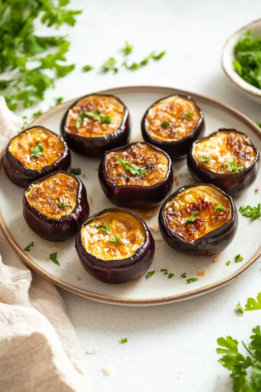 Plated eggplant with a shiny, savory glaze and a garnish of spring onions.