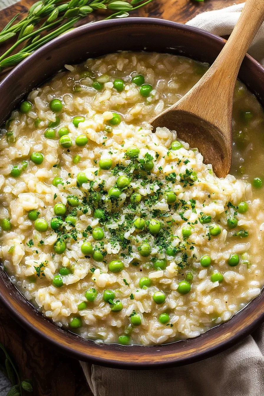 Traditional Italian rice and peas dish garnished with fresh herbs.