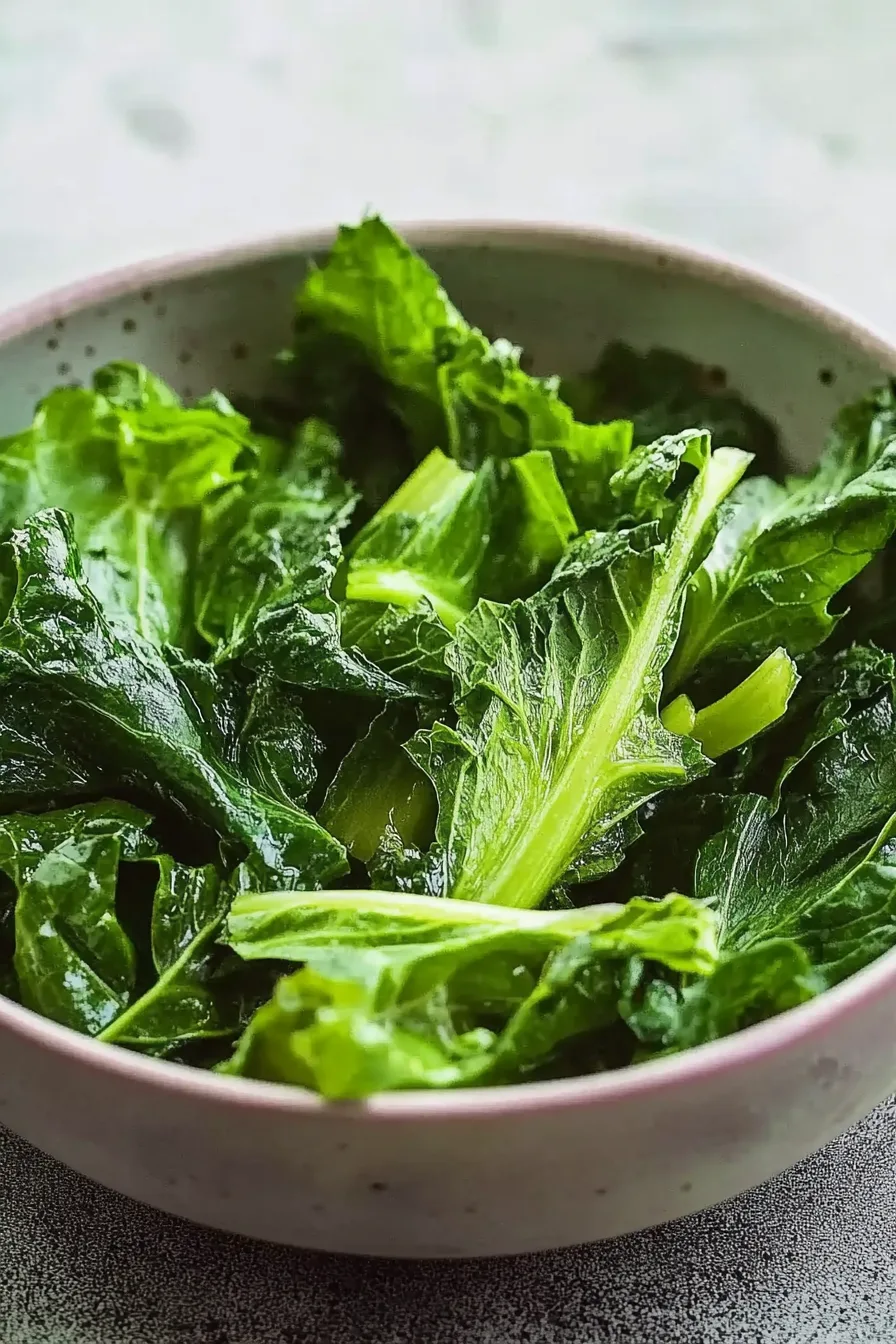 Close-up of bright green leafy vegetables lightly coated in seasoning.