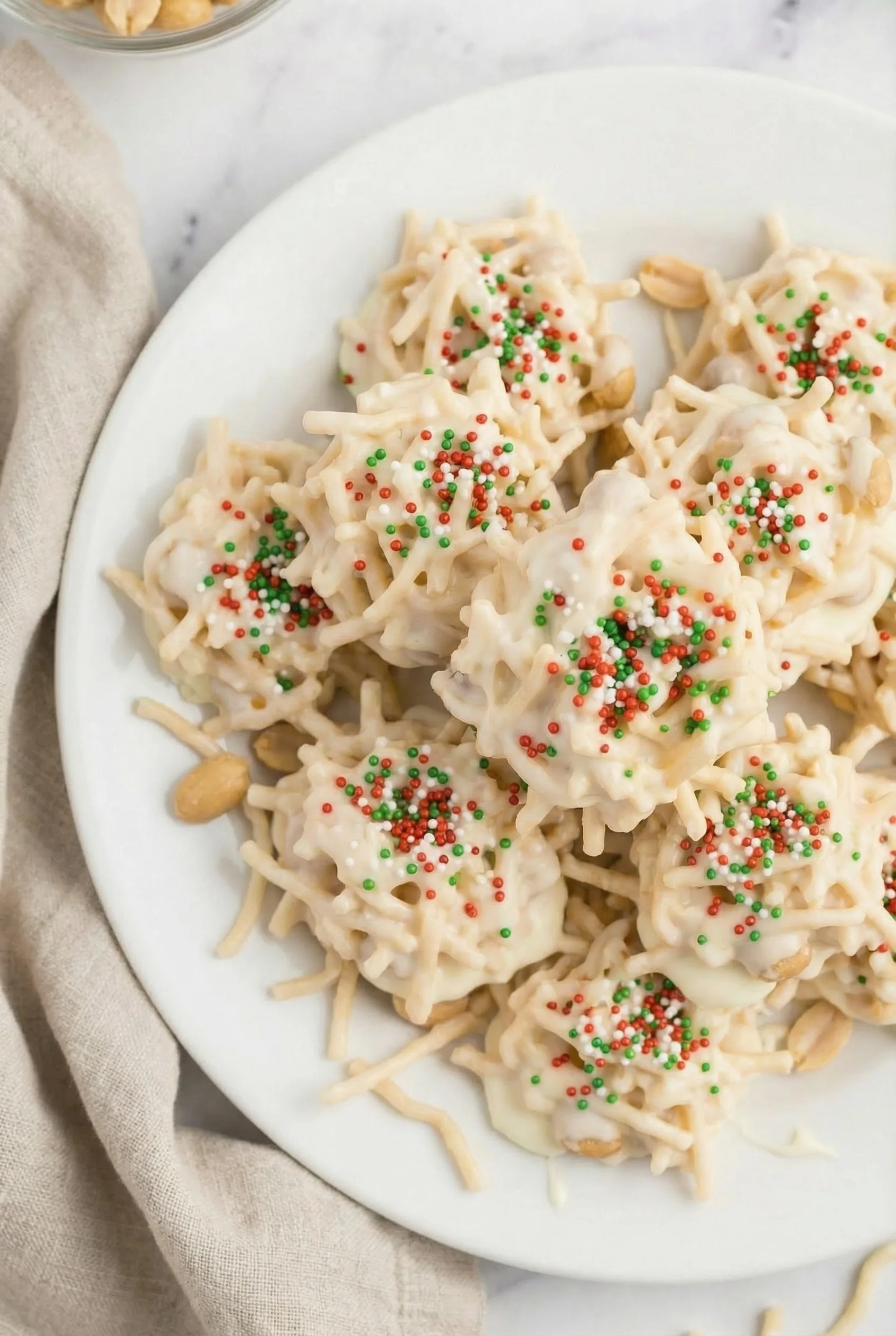 A close-up of creamy, textured candy clusters arranged on a white plate.