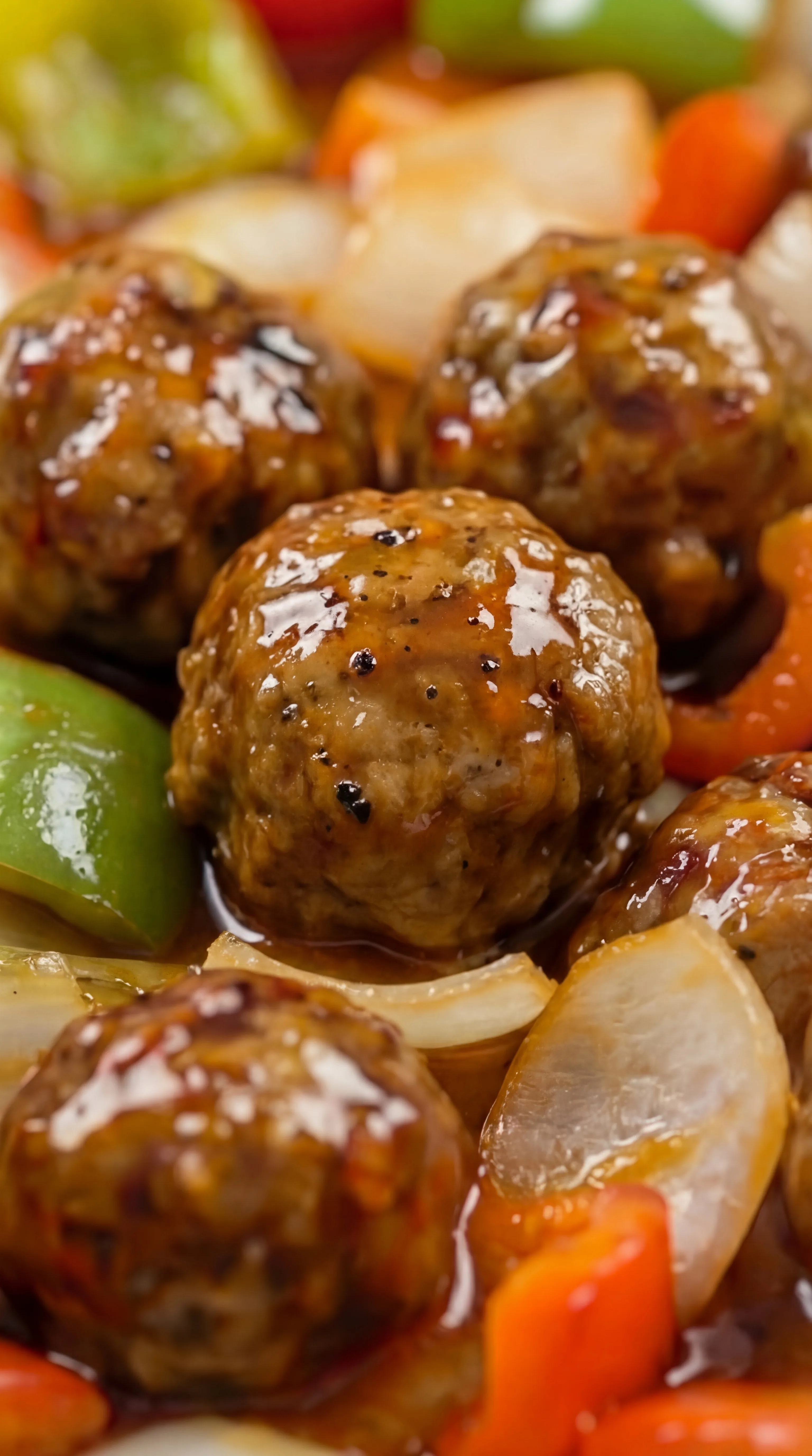 juicy meatballs coated in thick sweet and sour sauce with tender peppers and onions