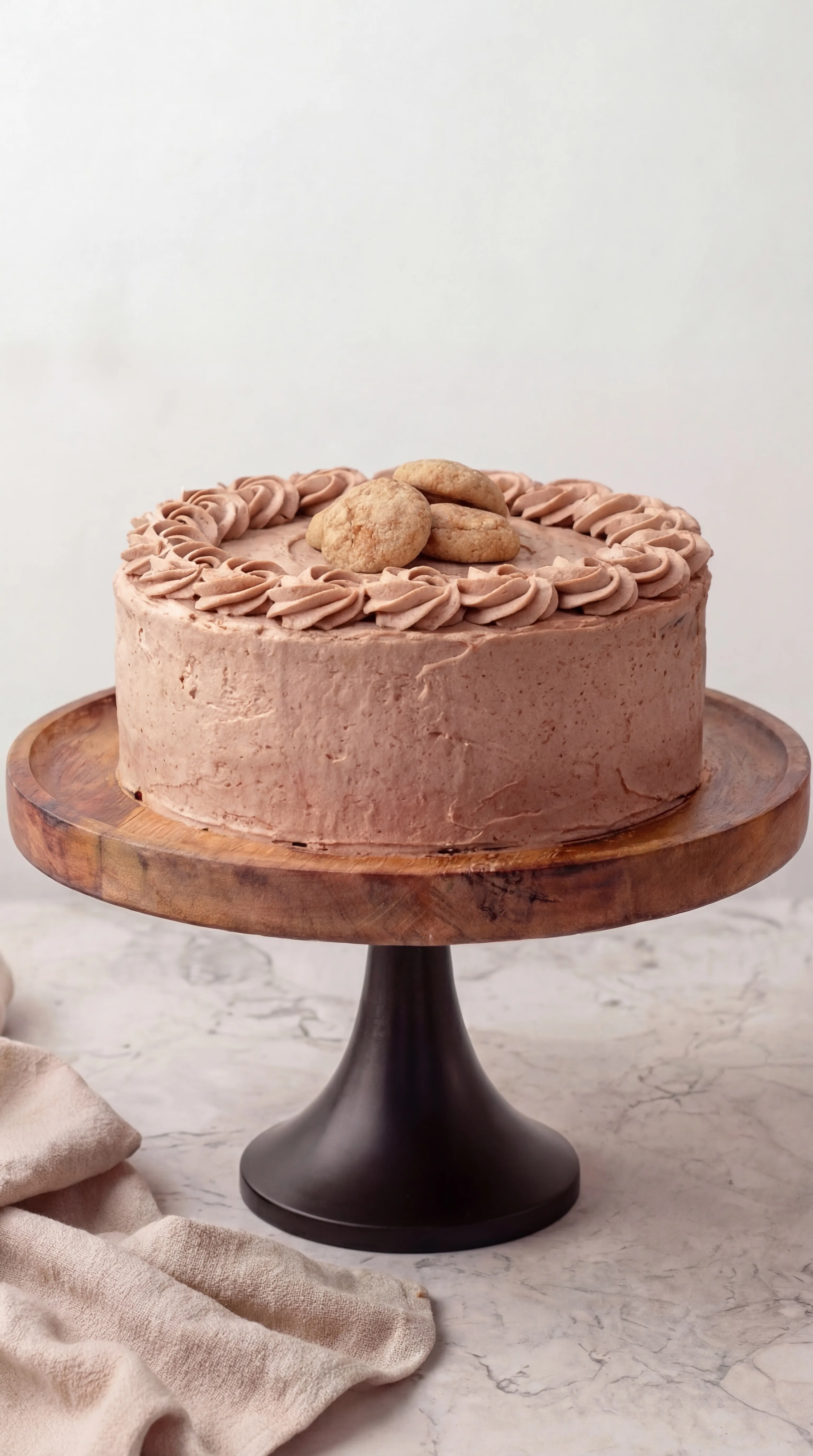 layered cinnamon cake with smooth buttercream frosting displayed on wooden cake stand