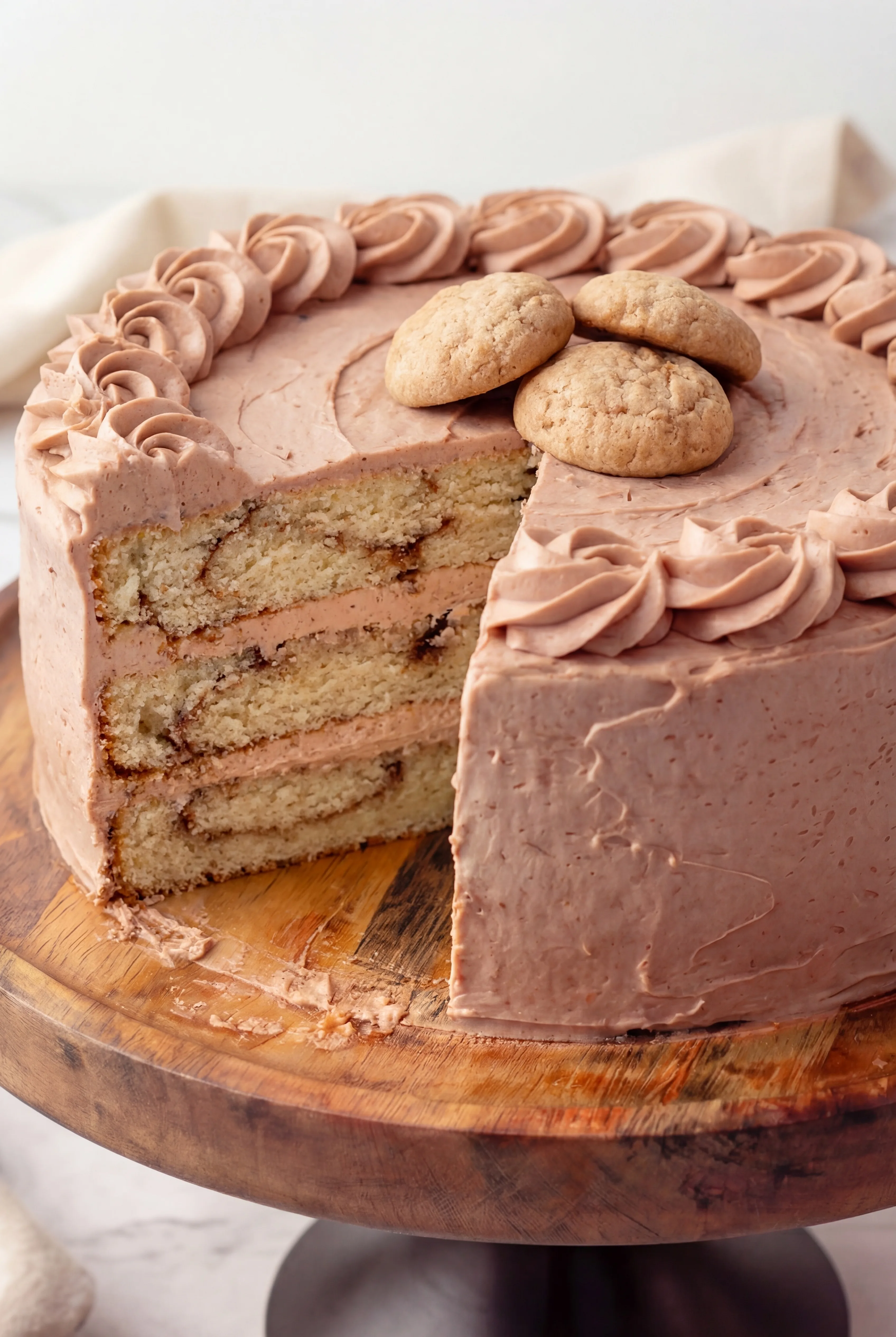slice of cinnamon swirl layer cake with creamy frosting and soft fluffy crumb